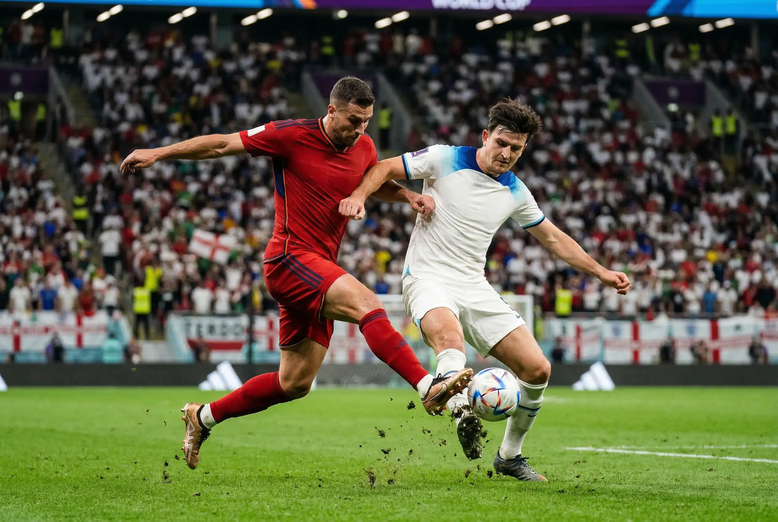 Zwei Fußballspieler im intensiven Zweikampf während eines WM-Gruppenspiels auf dem Rasen