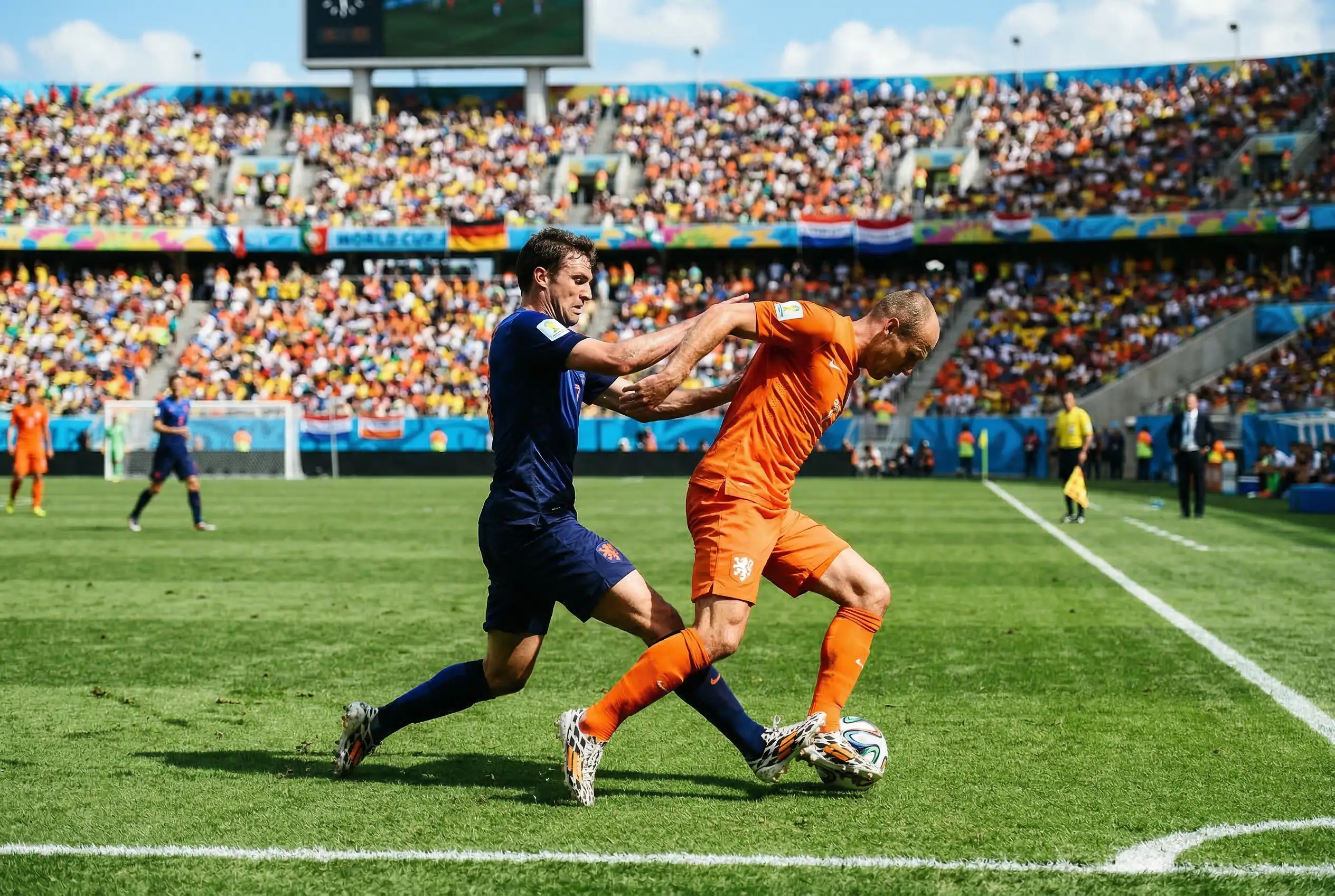 Fußballspieler im Zweikampf auf dem Rasen während eines WM-Gruppenspiels bei Tageslicht
