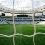 Fußballstadion mit Anzeigetafel und grünem Rasen als Hintergrund für die WM 2026 Wetten FAQ
