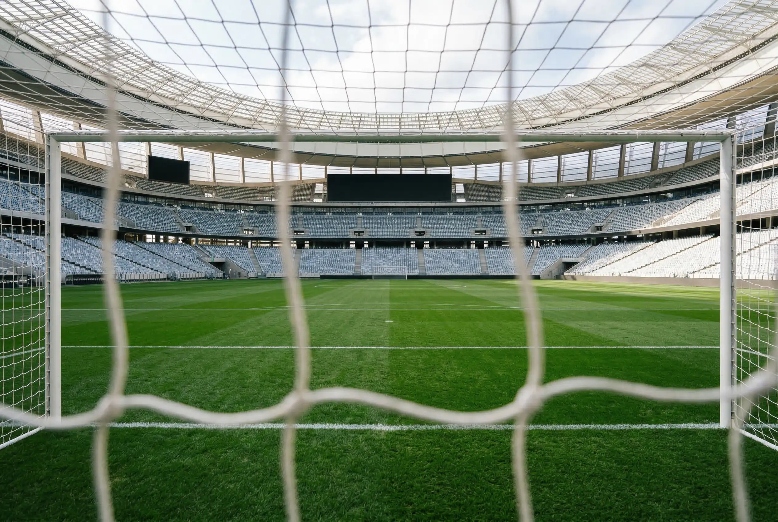 Fußballstadion mit Anzeigetafel und grünem Rasen als Hintergrund für die WM 2026 Wetten FAQ